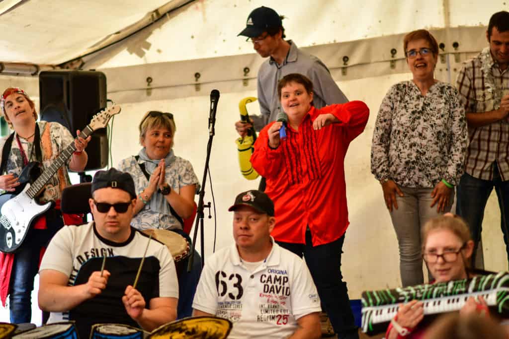 Eine Gruppe von Menschen, die Musik zusammen macht und dabei auf einer Bühne stehen.