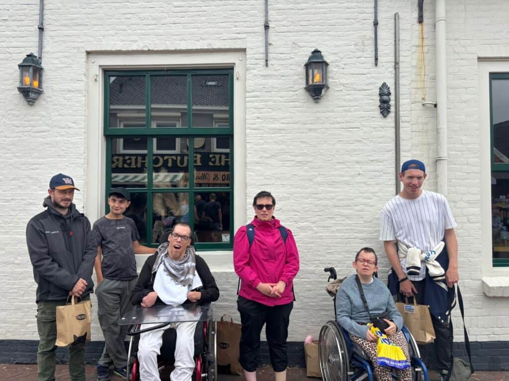 Eine Gruppe von Menschen posiert vor einem weißen Gebäude.