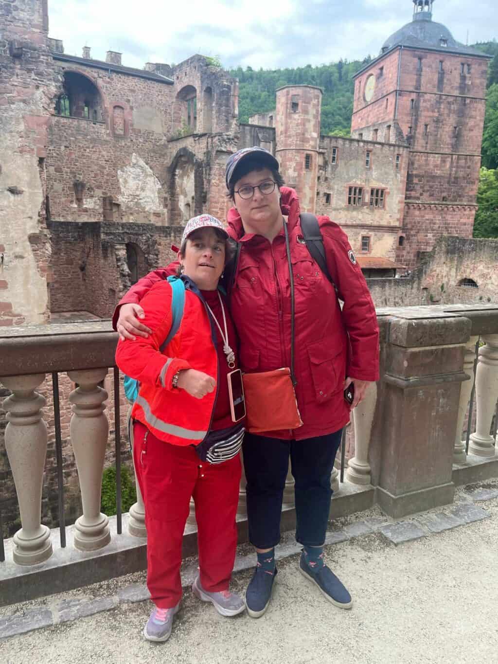 Zwei Personen stehen vor der Ruine eines historischen Schlosses.